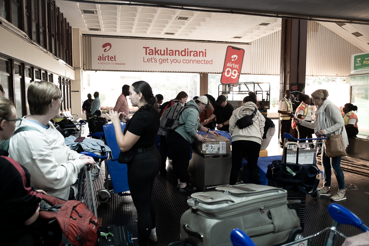 Service trip participants gathered in a group with luggage everywhere!