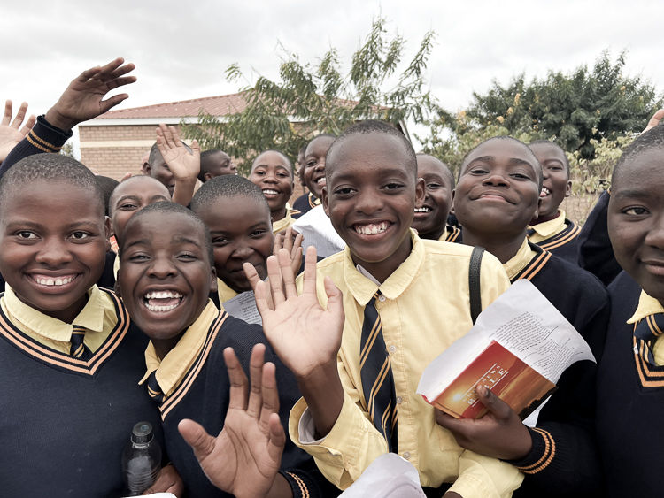 Kuwala students outside St. Peter's Assembly hall all smiling for the camera in tight group.